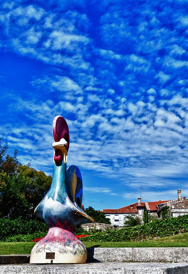 Galo de Barcelos colorido em exibição ao ar livre.